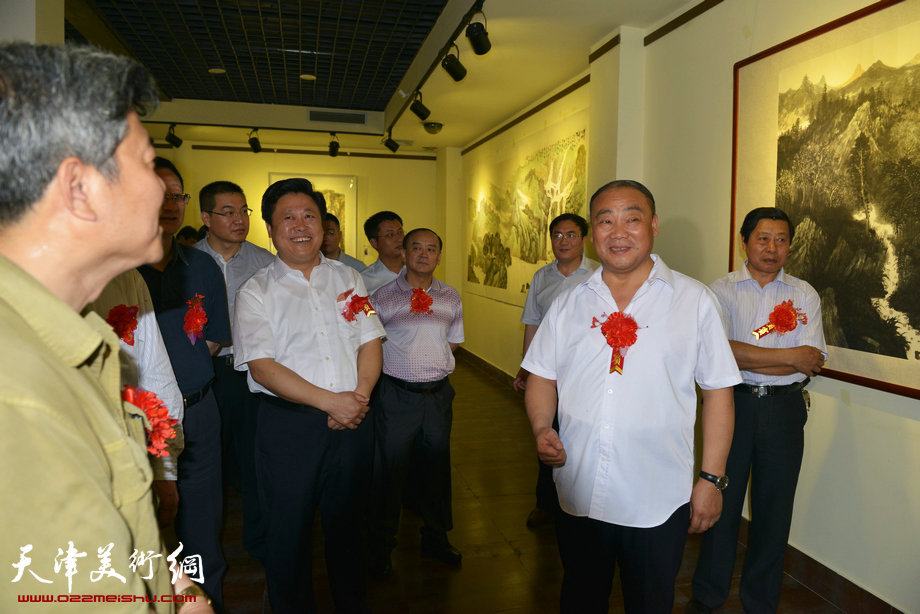 “梦现故乡—赵忠仁水墨山水艺术展”青州开幕，图为赵忠仁陪同中共青州市委常委、政法委书记王树国等观看画展。