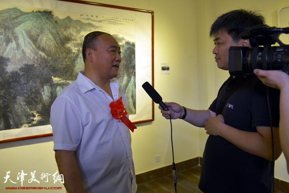 “梦现故乡—赵忠仁水墨山水艺术展”青州开幕，图为赵忠仁在画展现场接受媒体采访。