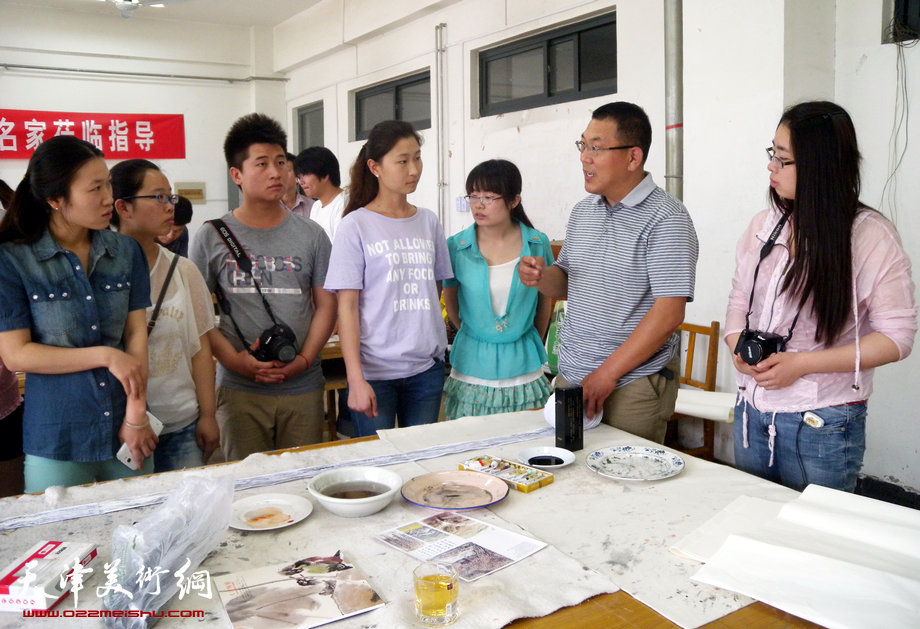 津门书画名家走进师大校园与师生交流。图为徐文汉在现场与同学交流