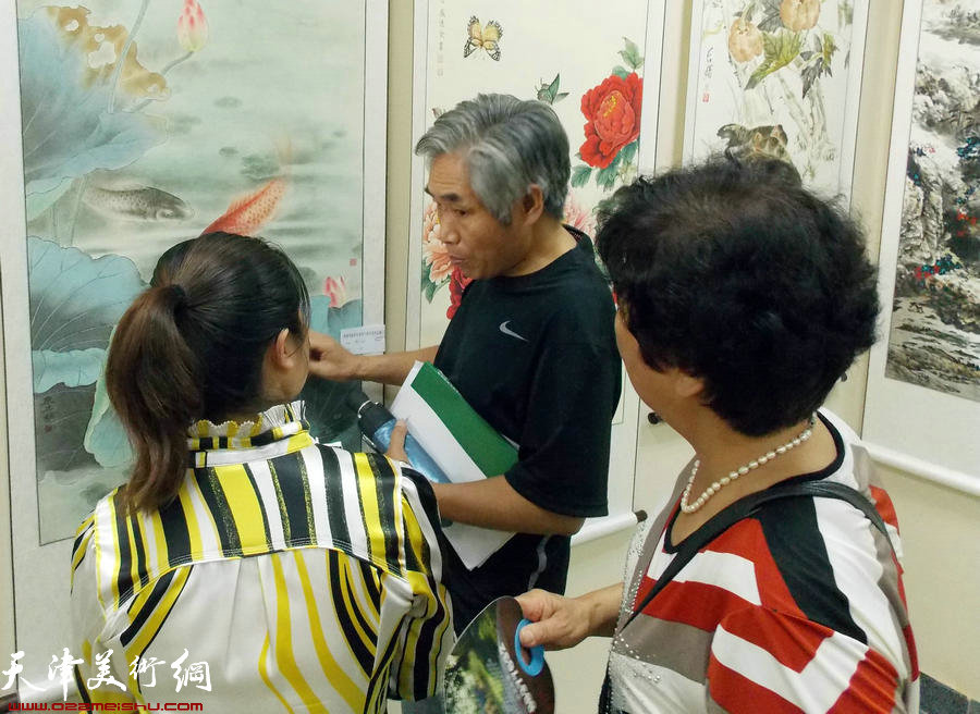 津报书画俱乐部第8届会员展揭幕。图为花鸟画家刘金标给会员点评作品