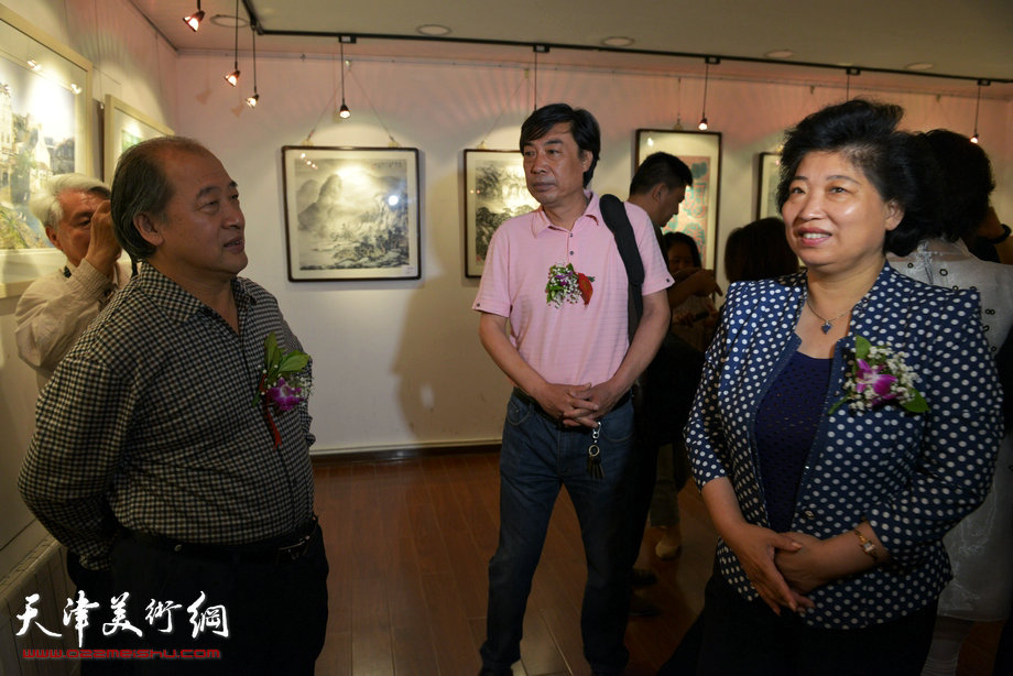 “津门知名画家精品联展”在圣和轩开幕，图为红桥区区长张泉芬、天津市美术家协会副主席王书平与画家杜晓光在画展现场。