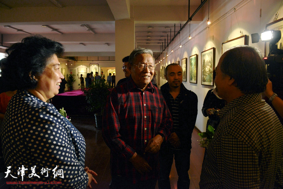 “津门知名画家精品联展”在圣和轩开幕，图为红桥区区长张泉芬、天津市美术家协会副主席王书平与画家张锡武在画展现场交流。