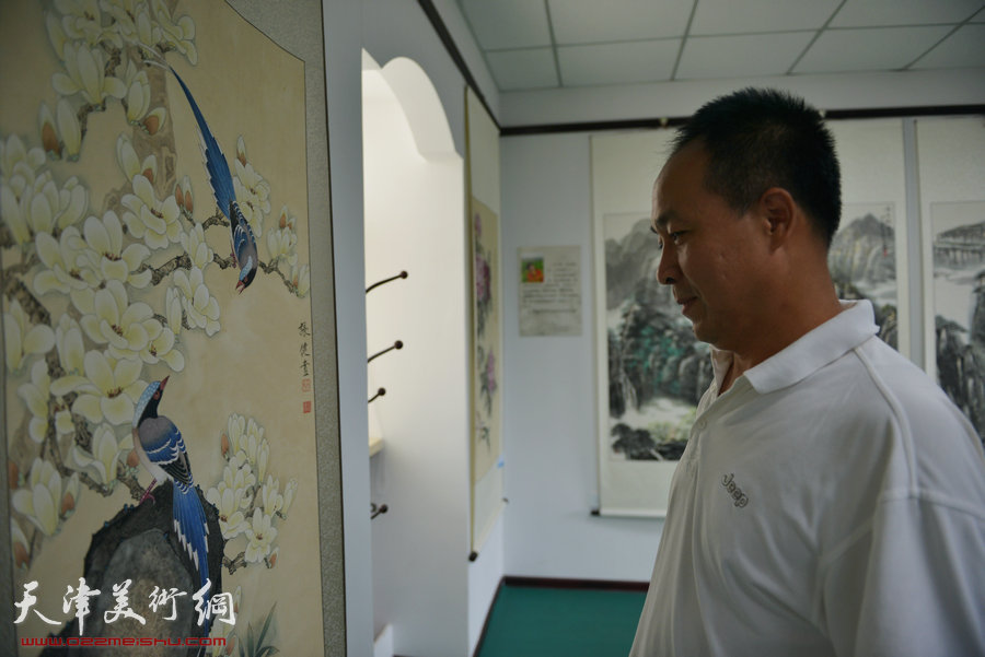 天津市“河东区美协十一人画展”开幕，图为王景奎在现场观赏作品。