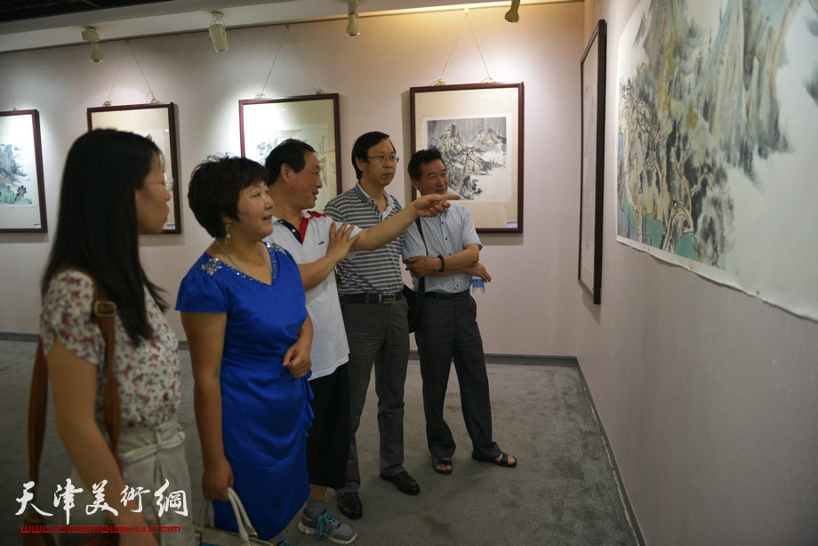 “诗画入境——闫勇国画作品展”8月17日在天津图书大厦六楼书天艺苑开幕。图为路洪明、陈之海、刘志军、张俊等在现场观画。