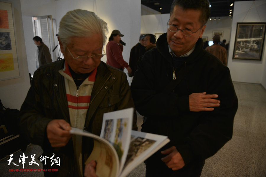 天津第七届水彩画展在财经大学艺术学院展馆举行，图为贺建国、吕培恒在画展现场。