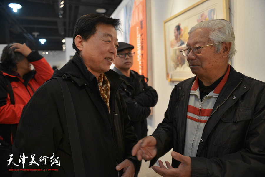 天津第七届水彩画展在财经大学艺术学院展馆举行，图为杨建国、贺建国在画展现场。