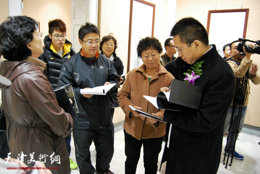 谦谦儒者 文人风骨—李毅峰中国画巡展青岛站反响热烈，图为李毅峰为热情的观众签名。