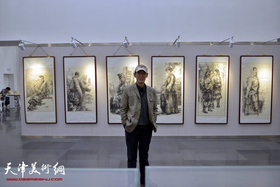 “跃马迎春京津画家国画新作展”1月15日在天津图书馆开幕，图为人物画家王印强在画作前。