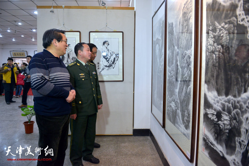 “鱼水情”迎新春书画展在北辰书画院举办，图为画家刘光明与部队官兵观看画展。