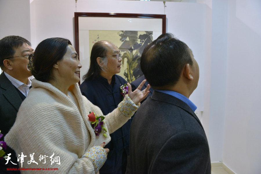 百花迎春—肖映梅写意画展在郭味蕖美术馆开幕，图为肖映梅陪同来宾观看展出作品。