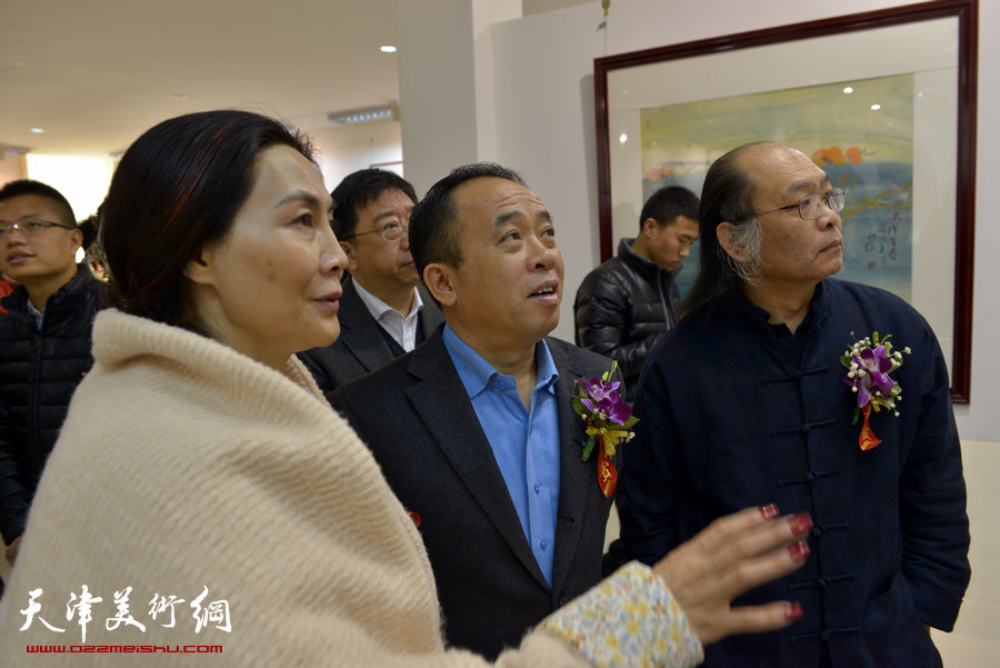 百花迎春—肖映梅写意画展在郭味蕖美术馆开幕，图为肖映梅陪同来宾观看展出作品。