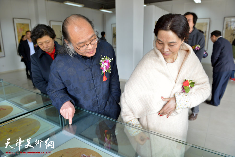 百花迎春—肖映梅写意画展在郭味蕖美术馆开幕，图为肖映梅陪同来宾观看展出作品。