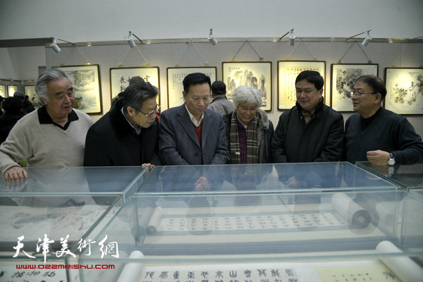 图为张建华、刘春雨、高占国等书画家在观赏作品。