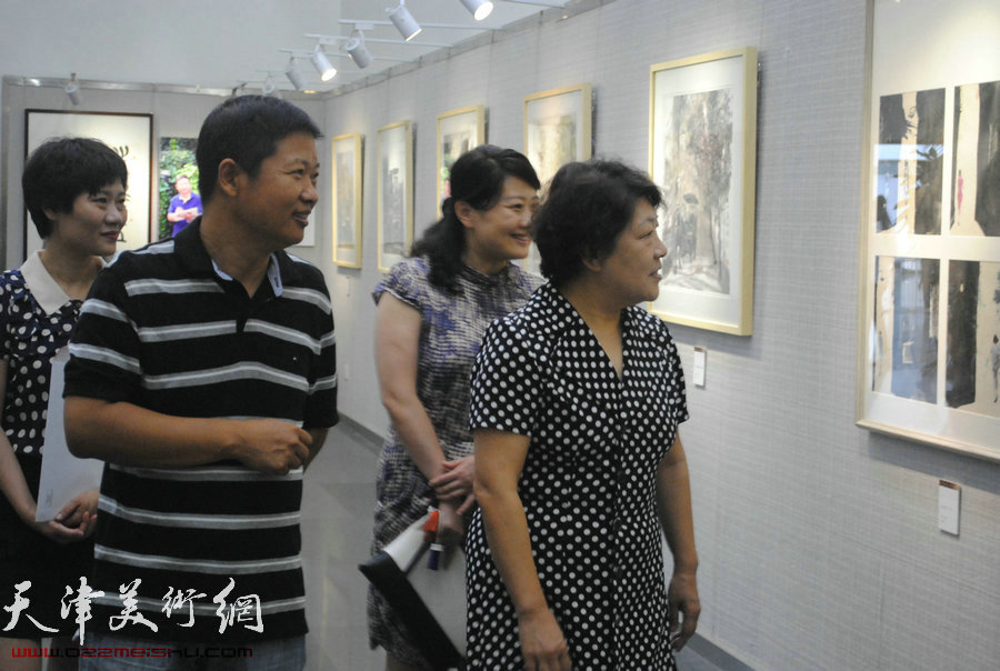 图为张俊芳、沙红、王伟观看“水墨五大道——魏瑞江画展”。
