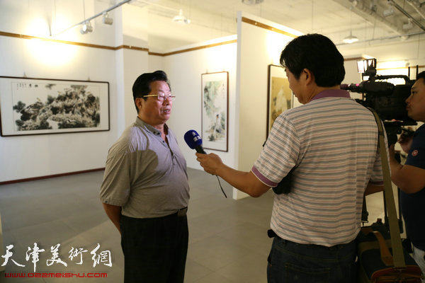 在张金荣画展开幕仪式上接受媒体采访的著名版画家赵海鹏