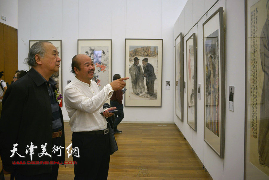 王振德、孟庆占在画展现场观赏作品。