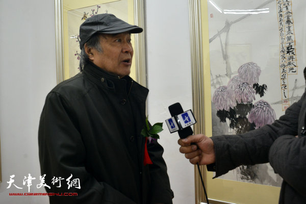 图为郭书仁在画展现场接受媒体采访。