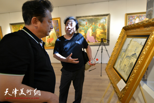 图为油画家高建章、沙志国在观赏俄罗斯大师油画。