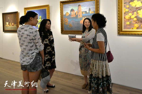 图为天津鼎天国际拍卖有限公司市场总监尤佳与来宾在画展现场。