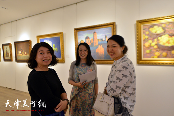 图为天津鼎天国际拍卖有限公司市场总监尤佳与来宾在画展现场。