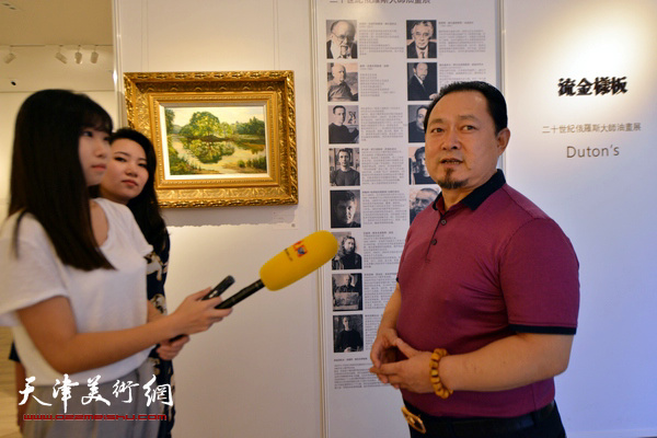 图为中俄油画协会、中俄国际美术馆陈文华在画展现场接受媒体采访。