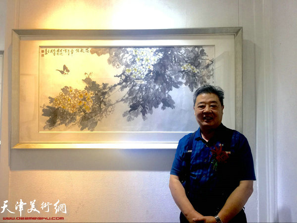 图为王其华与他创作的国画《老挝国花一鸡蛋花》