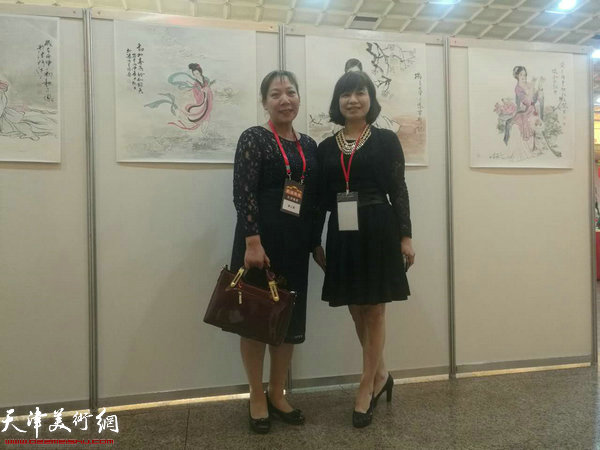 郑二凤在画展展出的自己画作前。