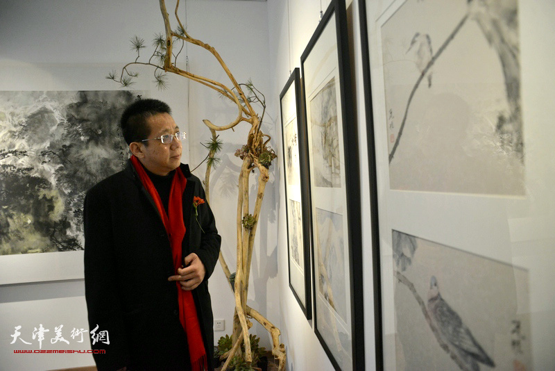 李毅峰在观赏展出的作品。