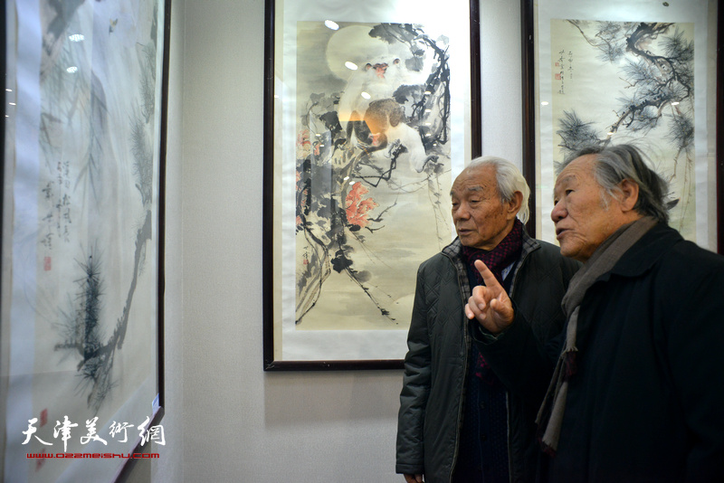 纪振民、姬俊尧在观赏展出的作品。