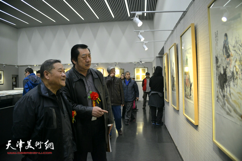 姬俊尧、孙玉河在观赏展出的画作。