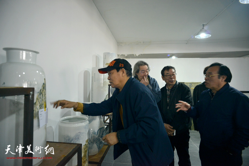 陈钢向马寒松、张亚光、时景林介绍“长城青花瓷”系列作品创作。
