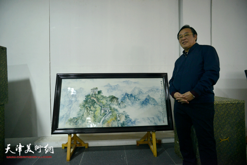 陈钢在创作的《黄崖关长城》瓷板画作品前。