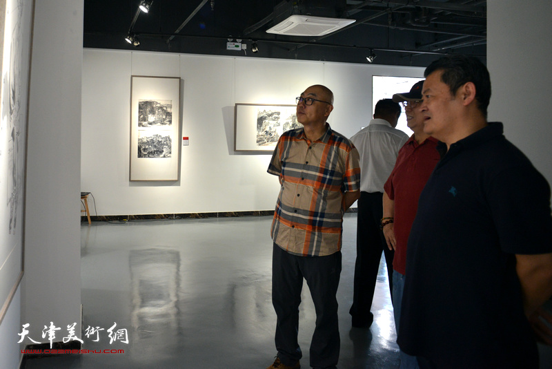 陈嵘、白鹏、高博在观看展出的作品。
