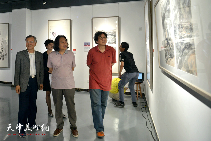 贾广健、晏平、张春燕在观看展出的作品。