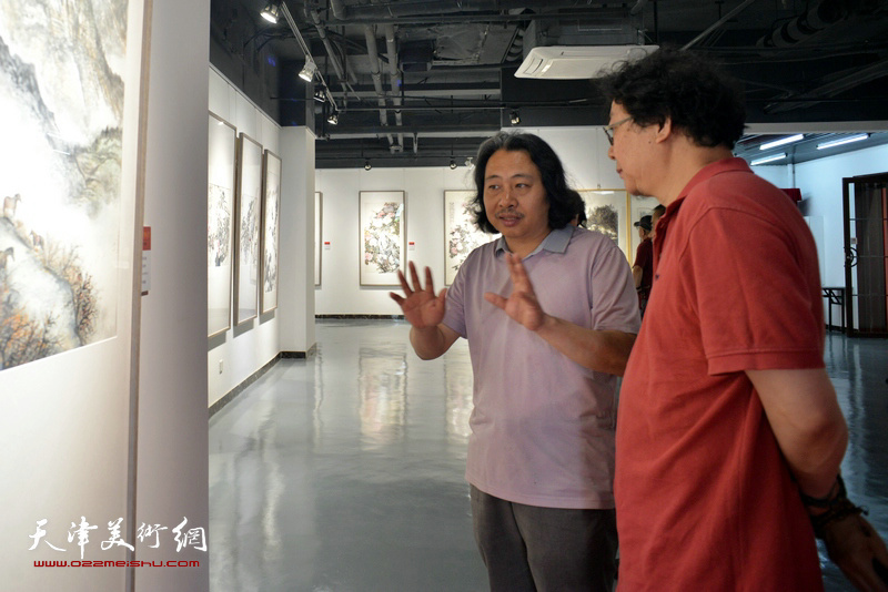 贾广健、晏平在观看展出的作品。