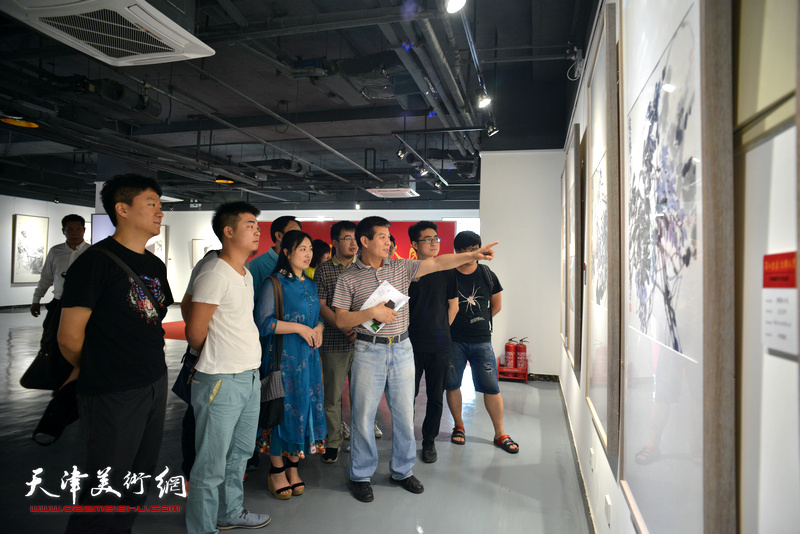 范扬与青创中心的青年国画家观看展出的作品。
