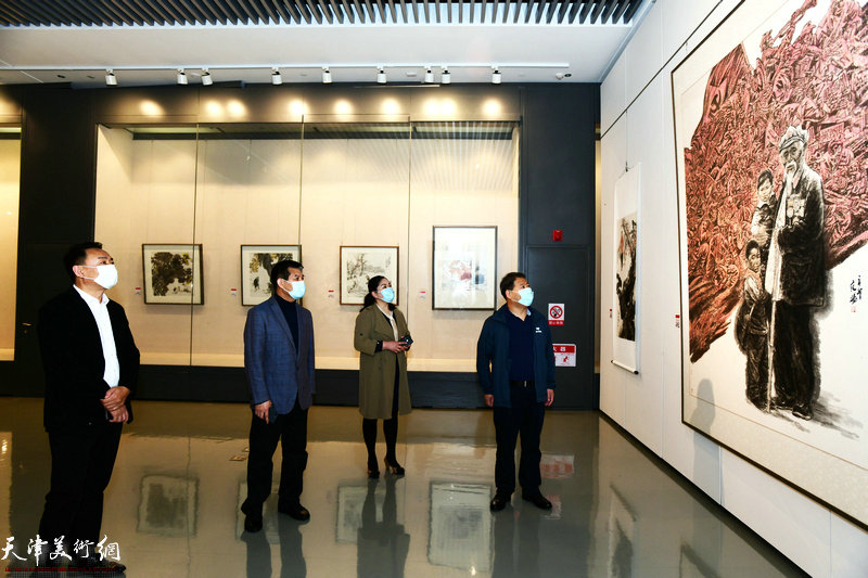 范扬陪同王会臣、田宝荣、陈广林观赏展出的作品。